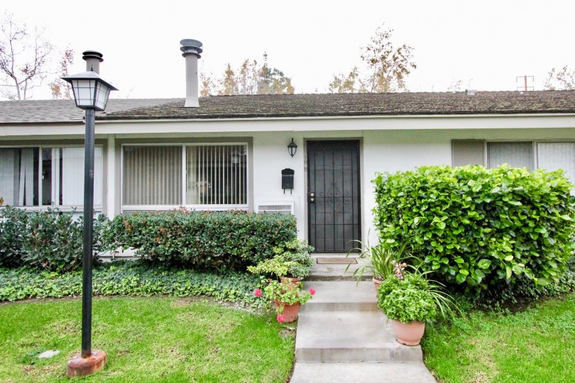 A great home in Sycamore Garden with tons of bushes in front.