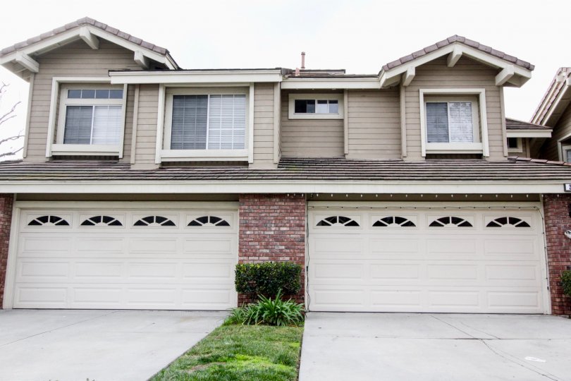 Large beige house with two two-car garages on an overcast day