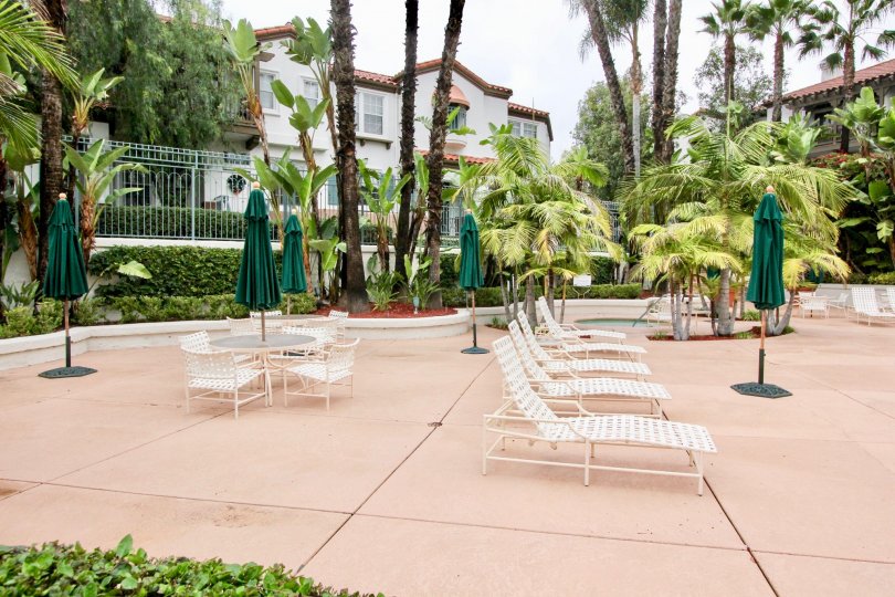 A public lounging area with closed umbrellas in the Tustin Del Verde community.