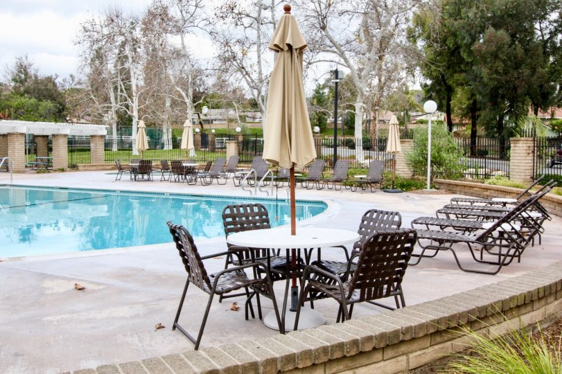 The sunny day in the Rancho Dominguez Townhomes with swimming pool and chairs.
