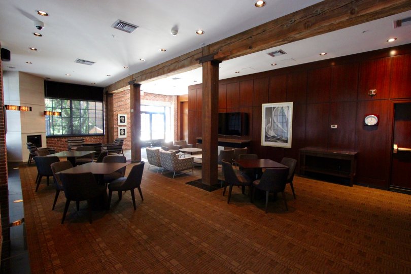 Tables with chairs inside a wood paneled room inside Cityfront Terrace in Downtown San Diego CA
