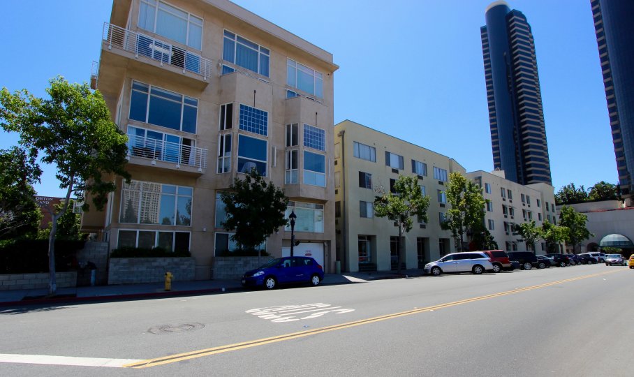 Fron. viewt of Island Lofts Condominium Downtown San Diego California with trees and parked cars