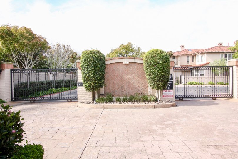 Two black gates on either side of a stone wall at Blackhorse in La Jolla California