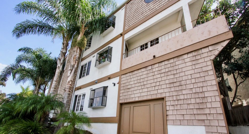 A brown and white shingled building with balcony in Ocean Beach, CA