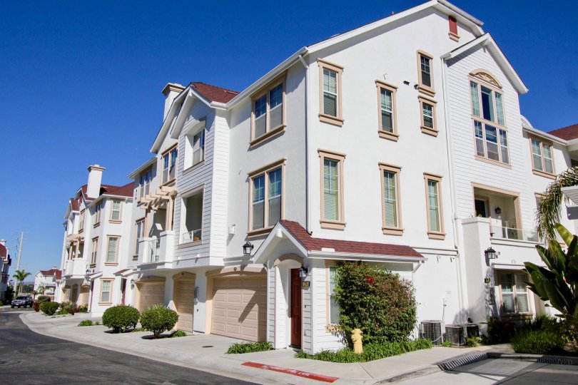 Three story residential building with flowered plants inside Harbor Cliff in Oceanside CA