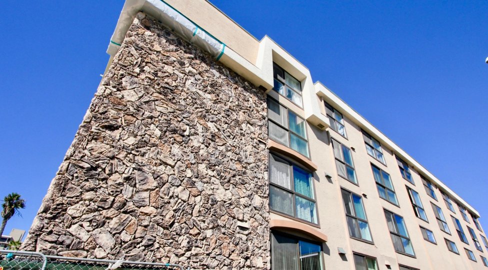 A mid-rise townhomes with stone cladding and sliding windows in the Ocean Point community.