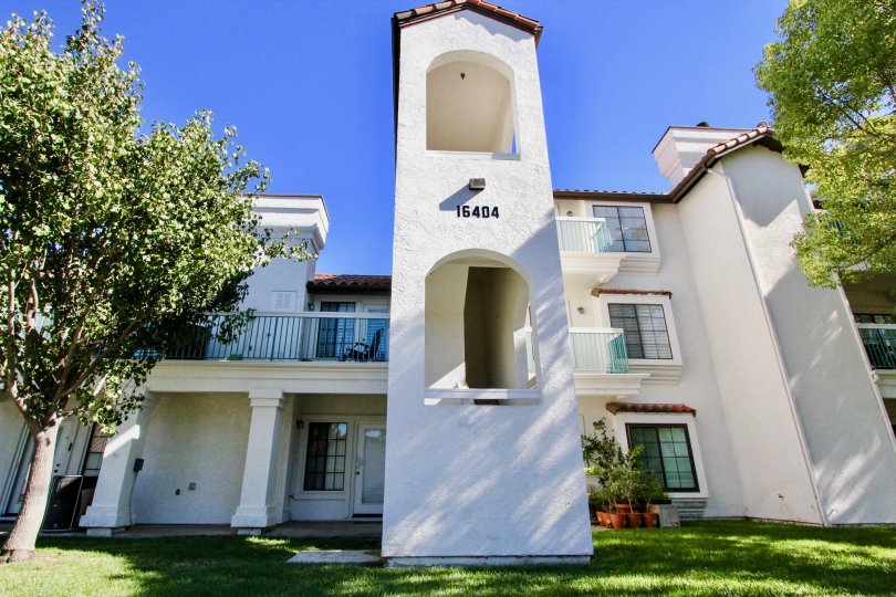 A big white house with a big lawn and some trees during a sunny day in Mira La Paz, Rancho Bernardo, CA