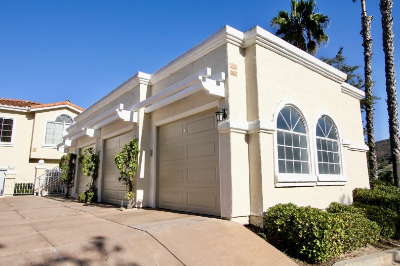 Thre garage doors sit closed on a small building in front of a residential building at Panorama