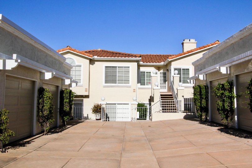 Pink driveway near garages & plants in Panorama at San Marcos CA